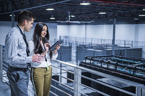 Business people using digital tablet over server room