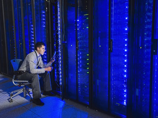 Hispanic technician working in server room