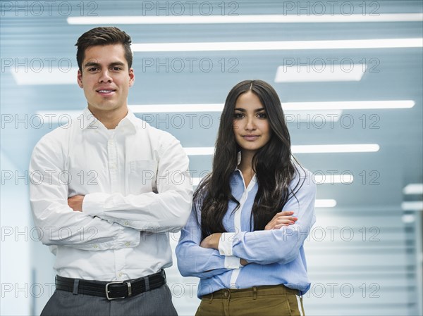 Business people standing with arms folded in office