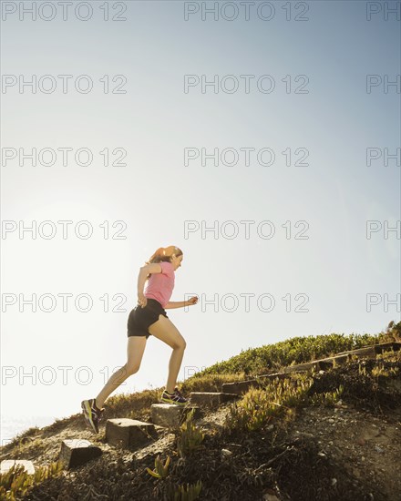 Caucasian woman jogging uphill
