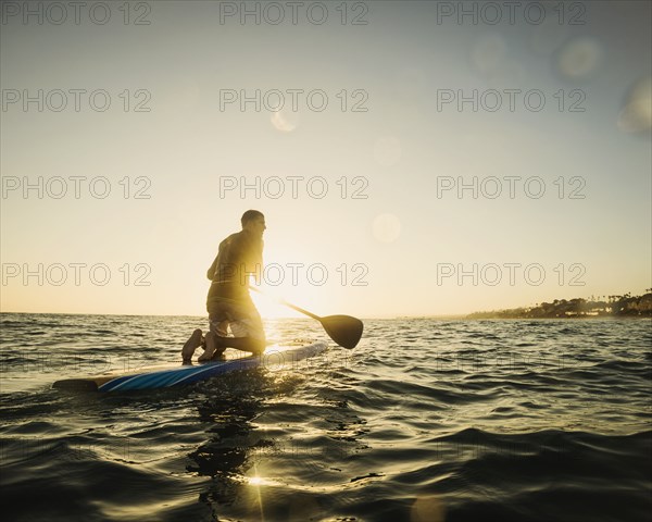 Caucasian man on paddle board in ocean