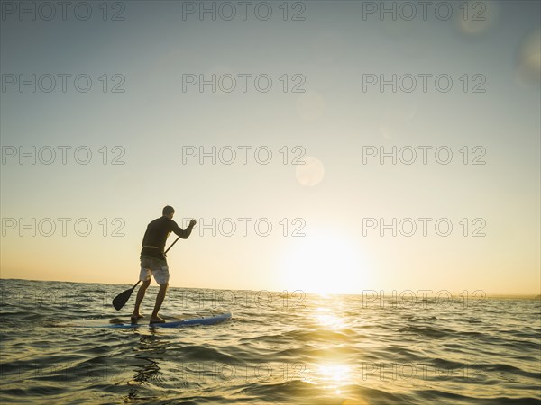 Caucasian man on paddle board in ocean