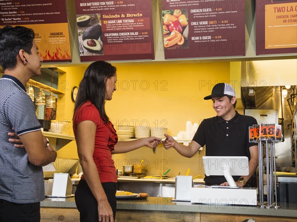 Hispanic woman purchasing food in cafe