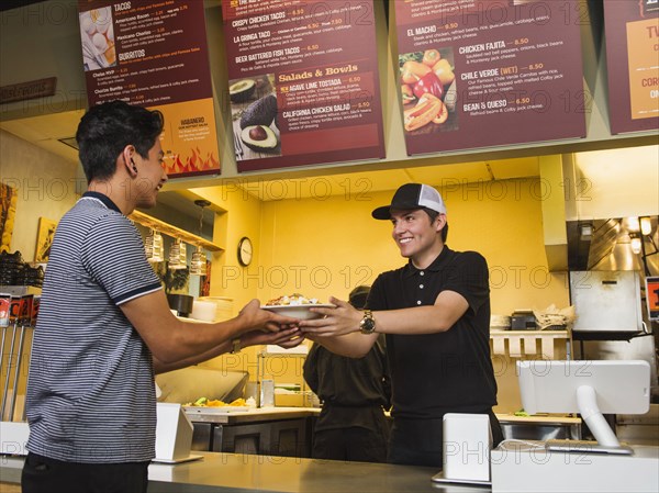 Hispanic man purchasing food in cafe