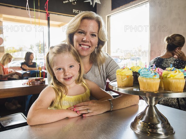 Caucasian mother and daughter smiling in cafe