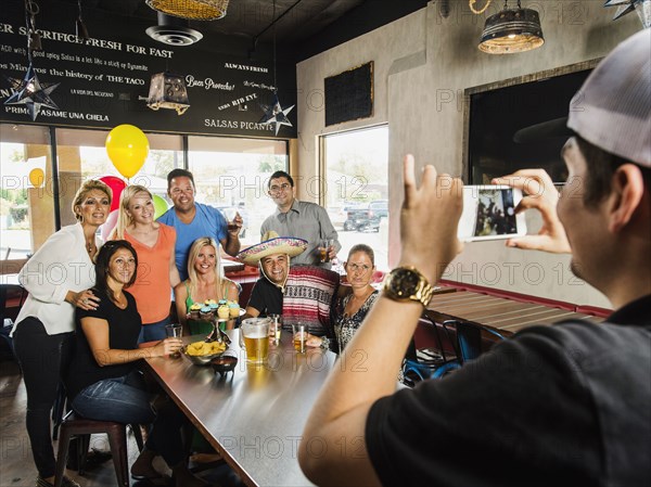 Man photographing friends in cafe