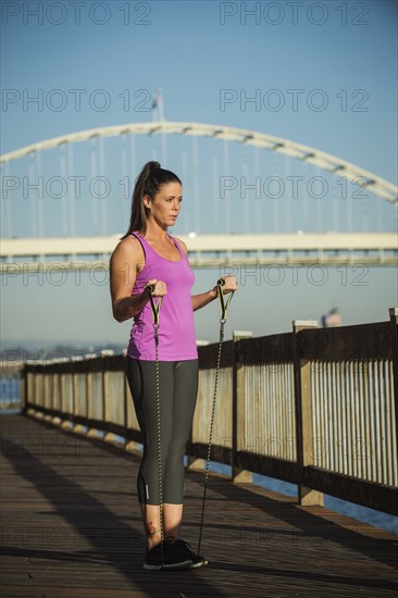 Caucasian woman working out on urban bridge
