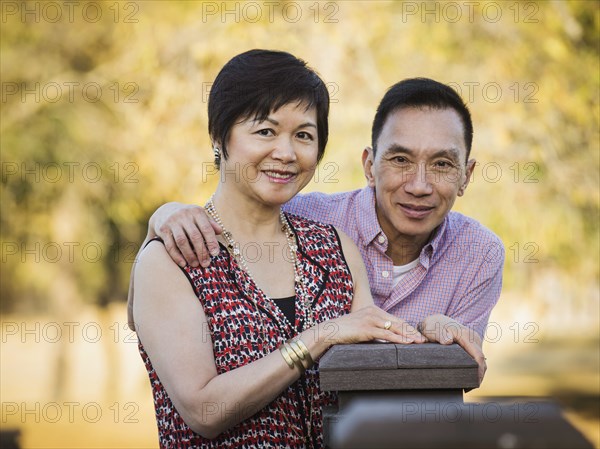 Older Chinese couple smiling outdoors