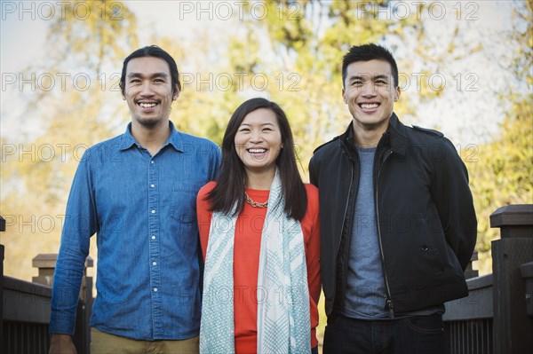 Adult Chinese siblings smiling outdoors