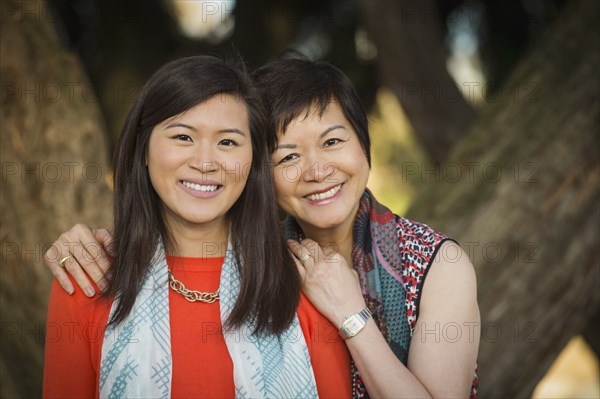 Chinese mother and daughter hugging outdoors