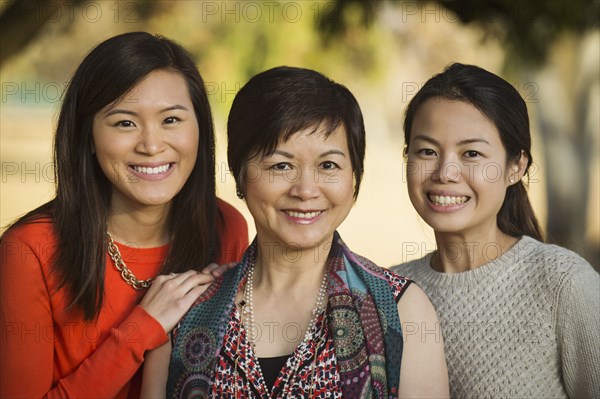 Chinese mother and daughters posing outdoors