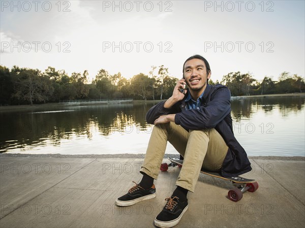 Chinese man talking on cell phone in park