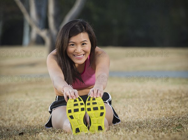 Chinese woman stretching in park