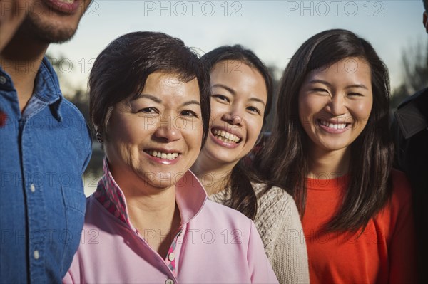 Chinese family smiling outdoors