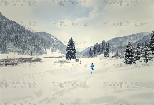 Caucasian woman running in snowy landscape