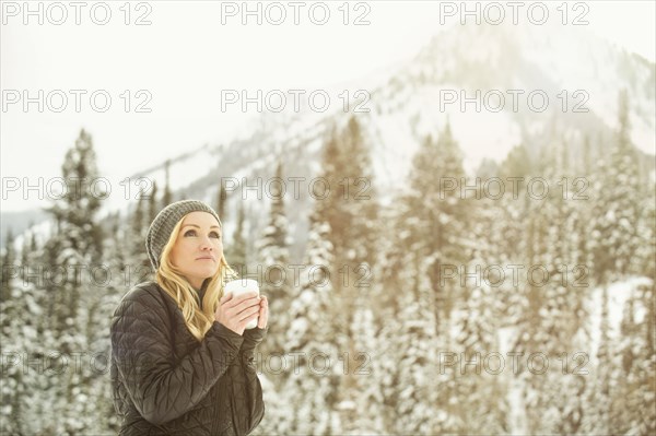 Caucasian woman drinking coffee in snow