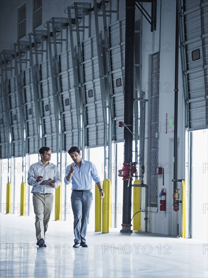 Businessmen walking with clipboard near open loading dock doors