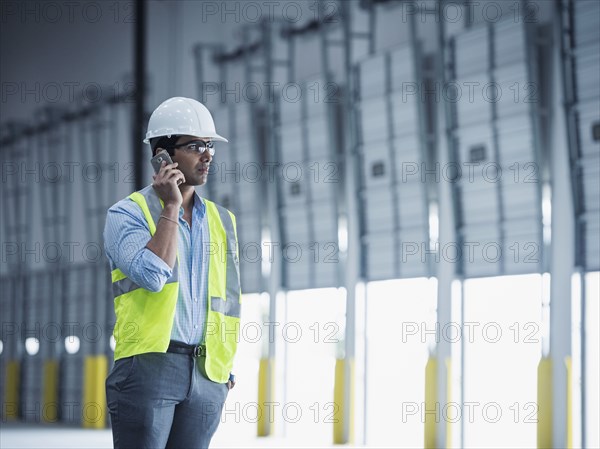 Indian worker talking on cell phone at loading dock