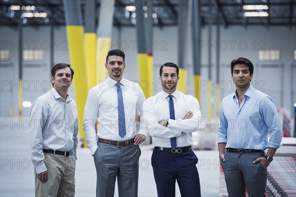 Smiling businessmen posing in empty warehouse