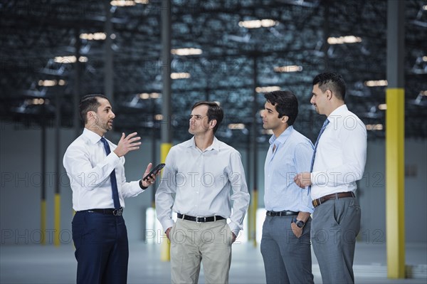 Businessmen talking in empty warehouse