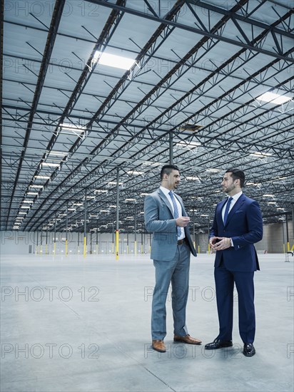 Businessmen talking in empty warehouse