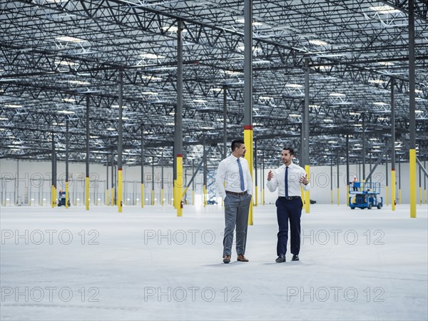 Businessmen talking in empty warehouse