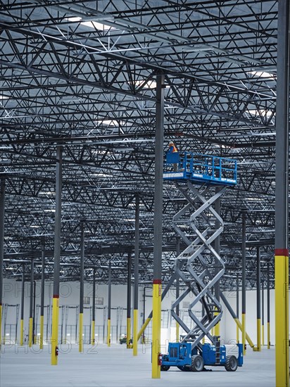 Indian worker on warehouse lift platform