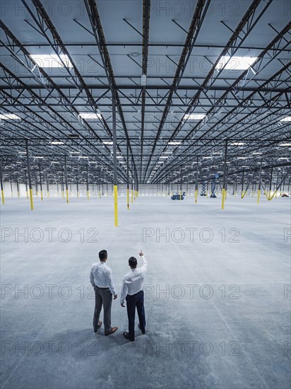 Businessmen talking in empty warehouse