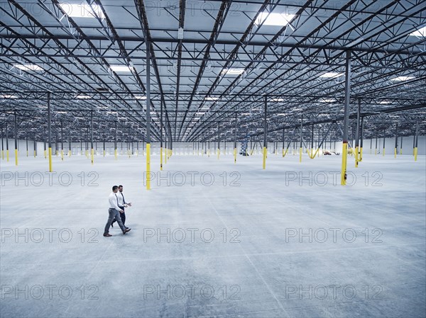 Businessmen walking in empty warehouse