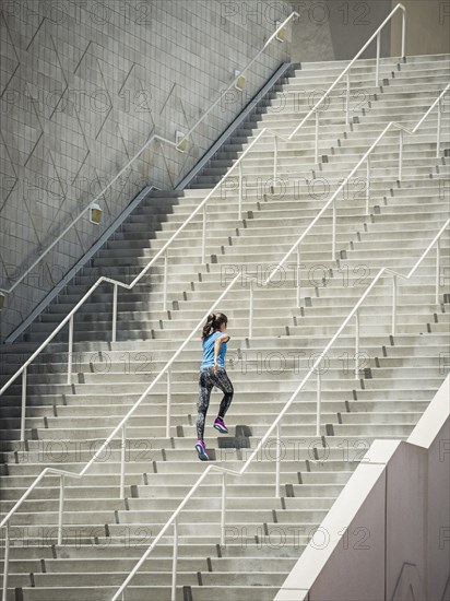 Caucasian woman running on staircase