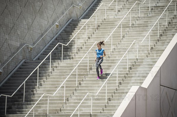 Caucasian woman running on staircase