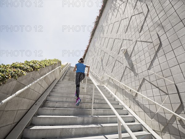 Caucasian woman running on staircase