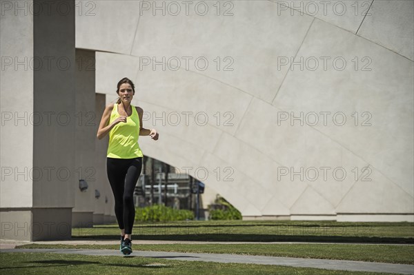 Caucasian woman running near pillars