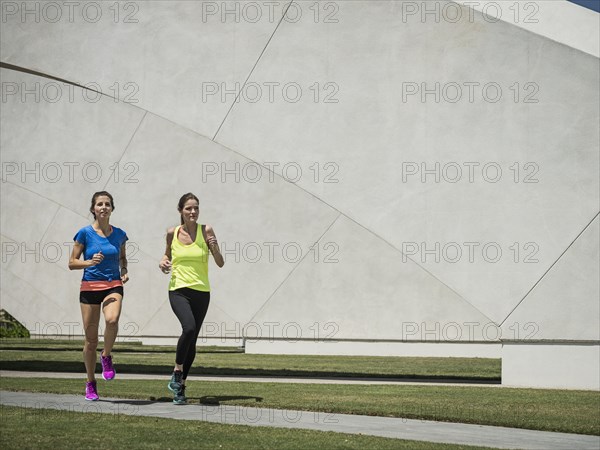Caucasian women running near architecture