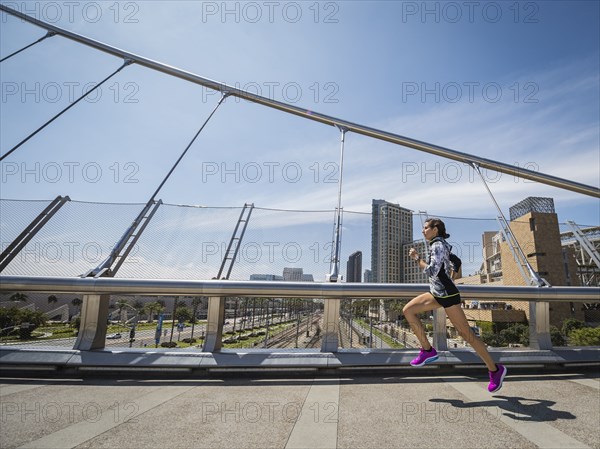 Caucasian woman running on bridge