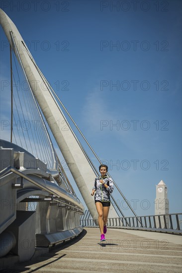 Caucasian woman running on bridge