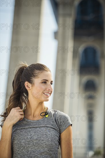 Smiling Caucasian woman standing under overpass