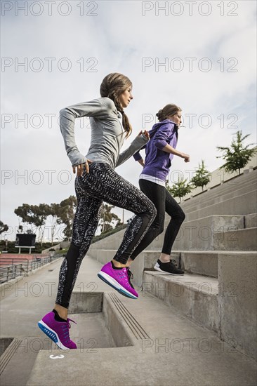 Caucasian women running on stadium staircase