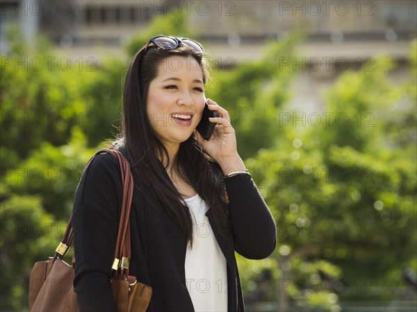 Chinese businesswoman talking on cell phone outdoors