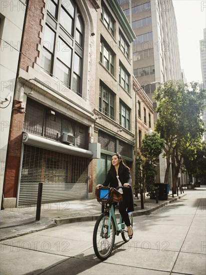 Chinese businesswoman commuting on bicycle in city