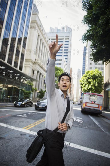 Chinese businessman hailing taxi in city