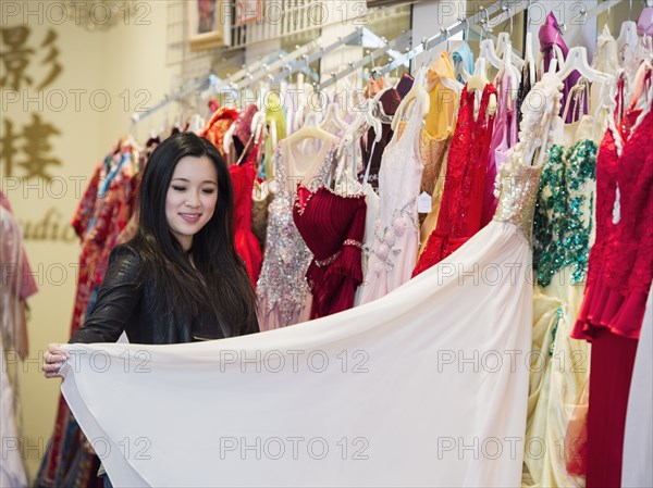 Smiling Chinese woman shopping for dress