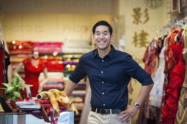 Smiling Chinese man posing in store