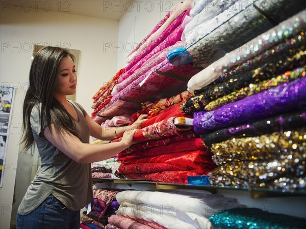 Chinese woman shopping for fabric in store