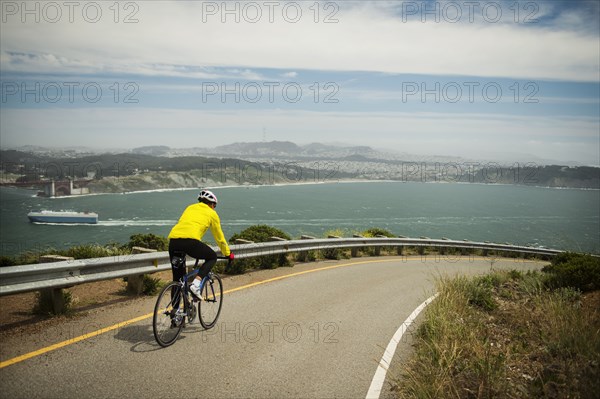 Hispanic man riding bicycle on waterfront road