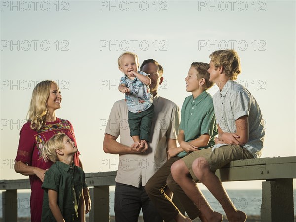 Caucasian family  watching baby boy stand on hands of father