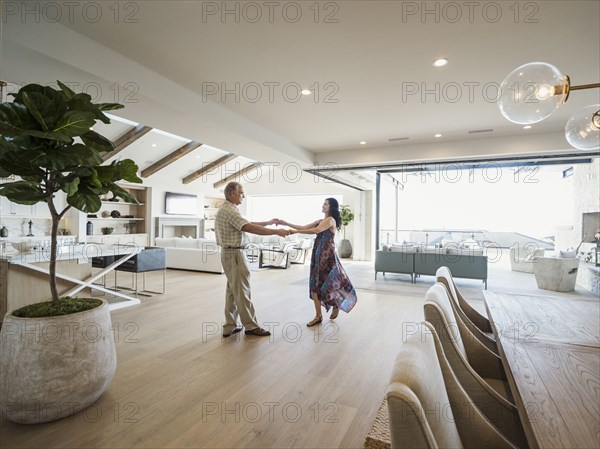 Older couple dancing in modern home