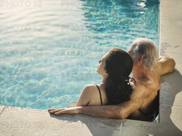 Older couple relaxing in swimming pool