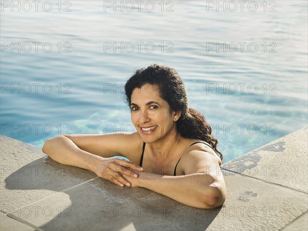 Portrait of Hispanic woman relaxing in swimming pool