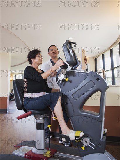 Physical therapist watching patient on exercise machine